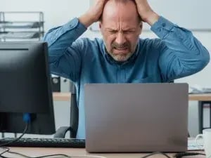 Frustrated person in front of laptop